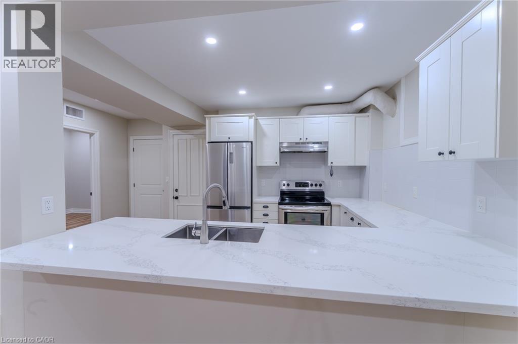 A modern kitchen with white cabinets and a marble countertop.