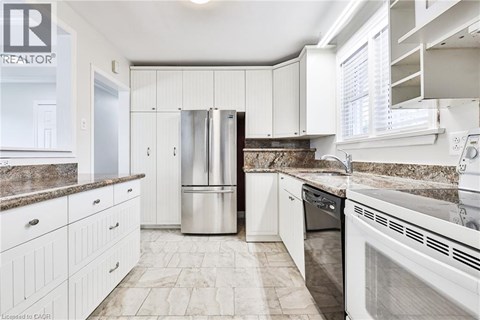 A kitchen with white cabinets and a marble countertop.