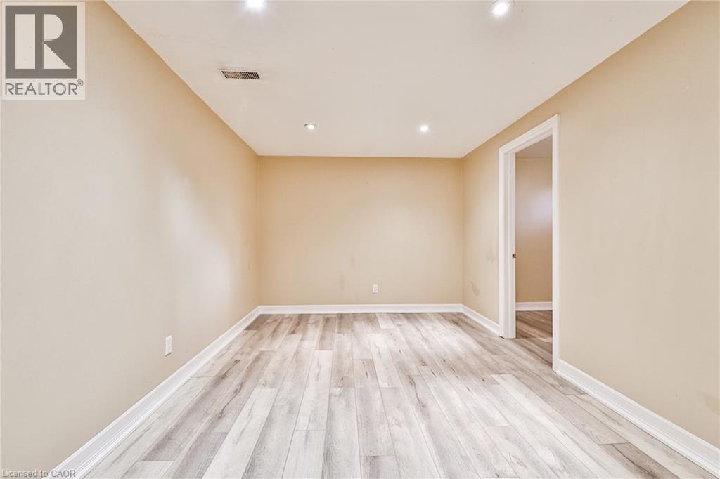 A spacious room with wooden flooring and a door on the right.
