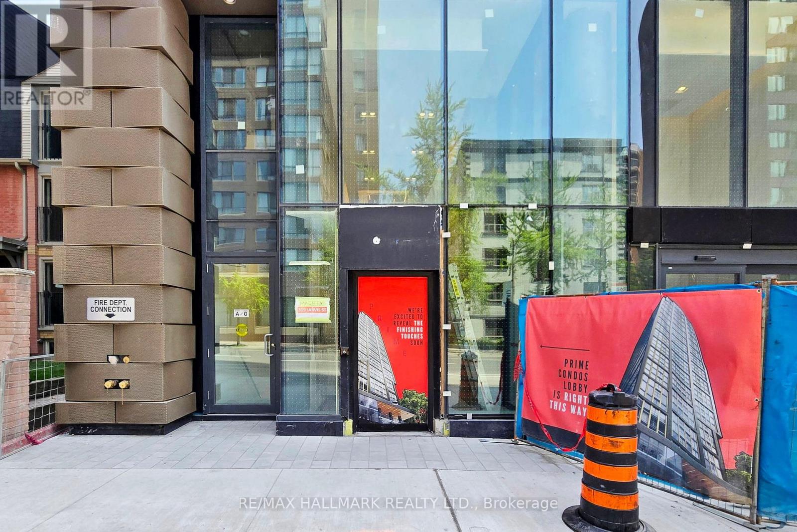 A building with a glass facade and a red sign on the door.