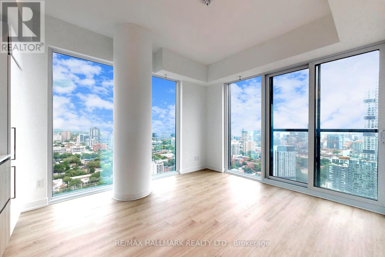 A spacious room with large windows overlooking a cityscape.