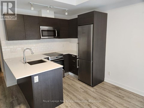 A kitchen with a black fridge and a white counter top.