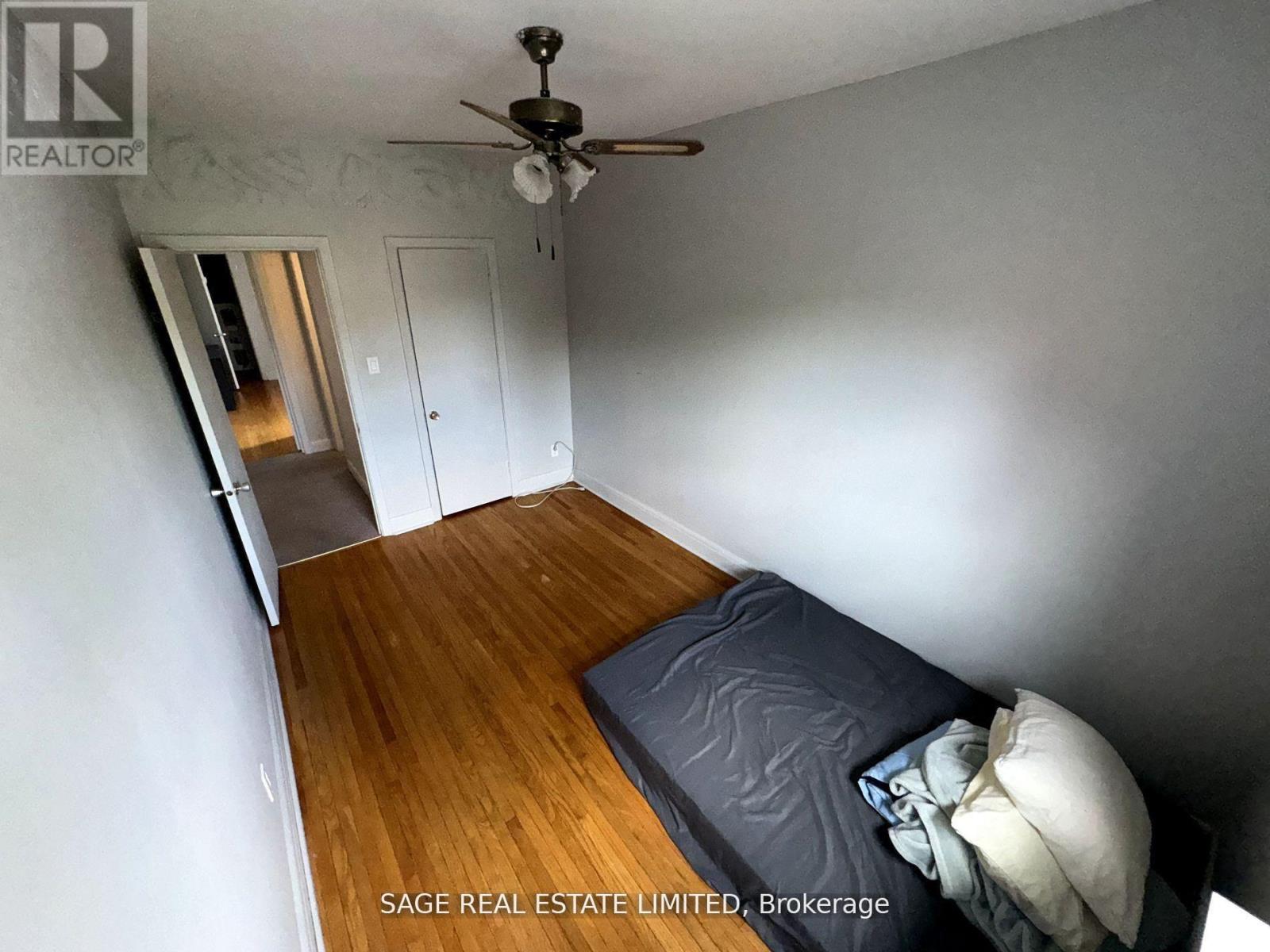 A bedroom with a bed and a ceiling fan.