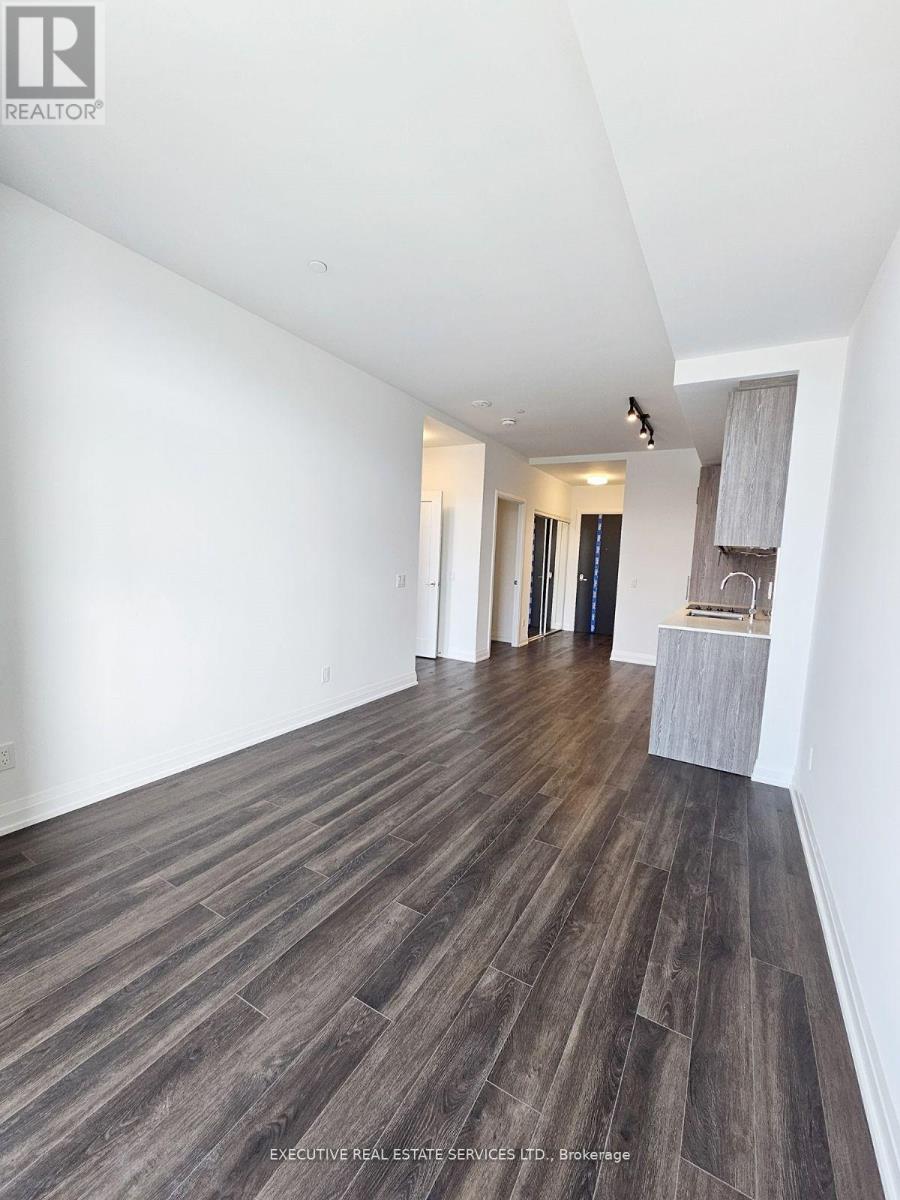 A room with wooden flooring and white walls.