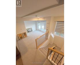 A view from the top of a staircase looking down at a living room.