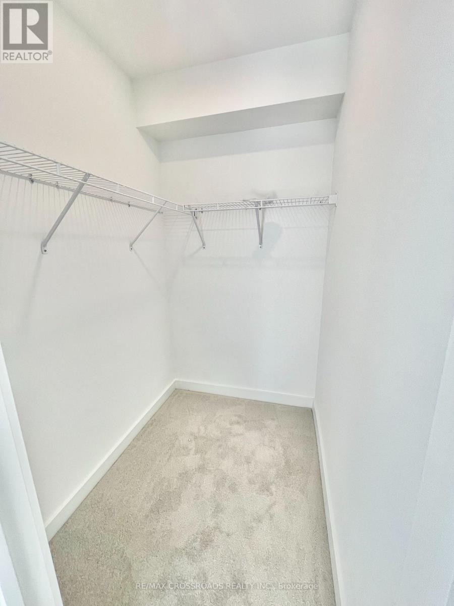 A white bedroom with a carpeted floor and a metal rack on the wall.
