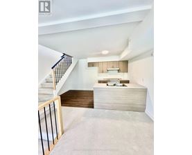 A modern interior space with a staircase leading to the upper level.