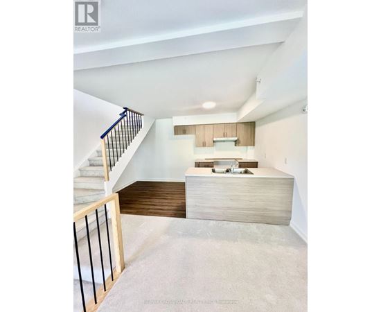 A modern interior space with a staircase leading to the upper level.