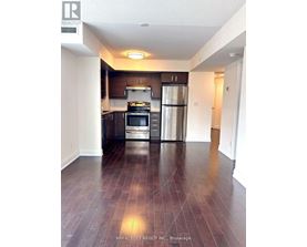 A kitchen with a refrigerator, oven, and stove.