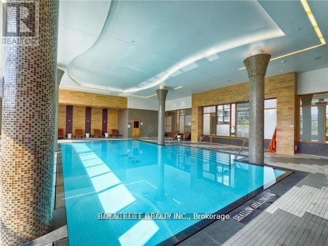A large indoor swimming pool with a tiled floor and a glass wall.