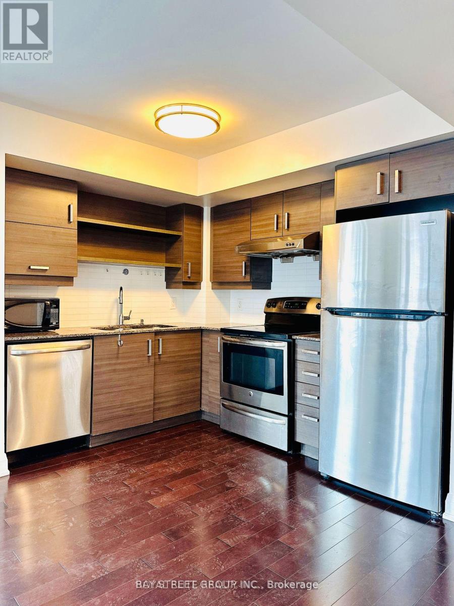 A kitchen with a refrigerator on the right side.