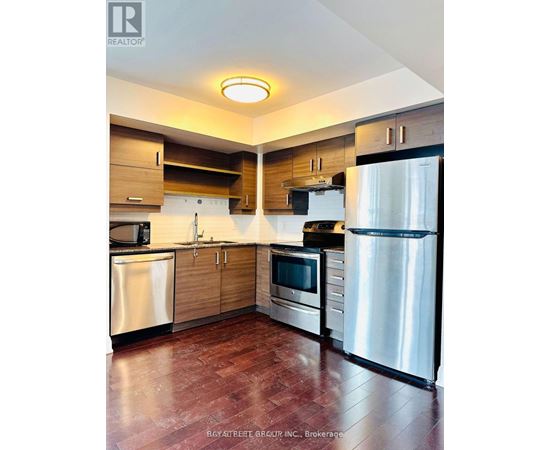 A kitchen with a refrigerator on the right side.