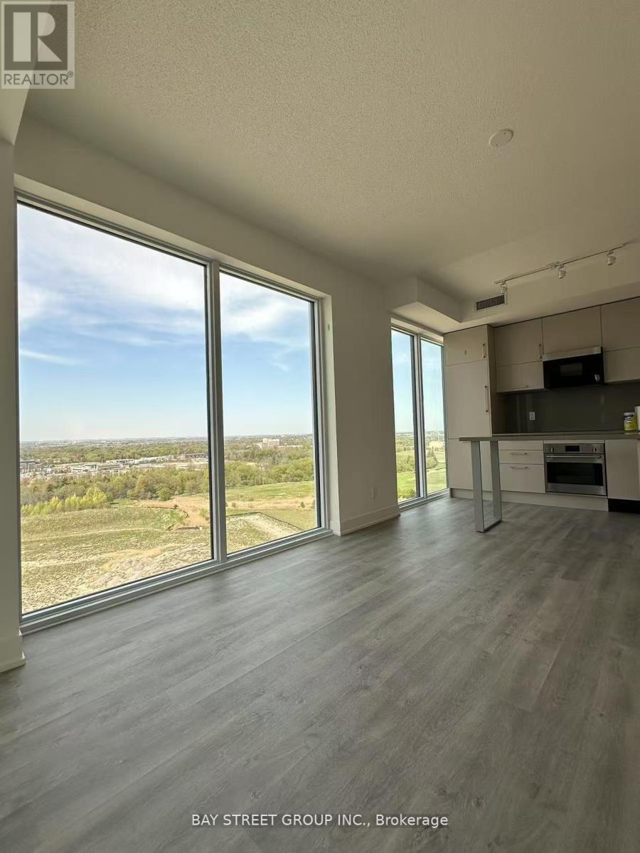 A spacious room with large windows overlooking a landscape.