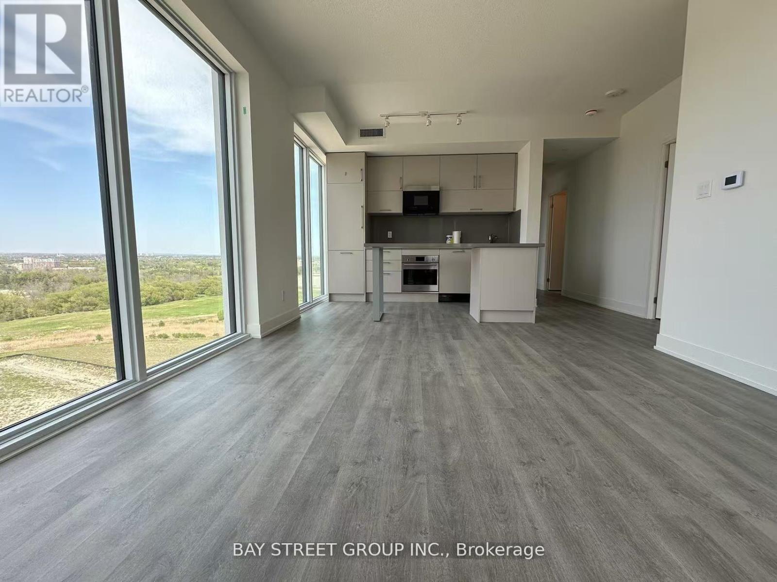 A spacious room with a view of the outdoors through large windows.