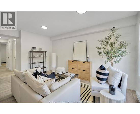A living room with a white couch and a wooden side table.