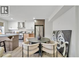 A modern kitchen with a dining table set for two.