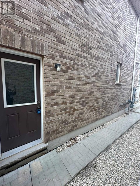 A brown door is on a brick wall.