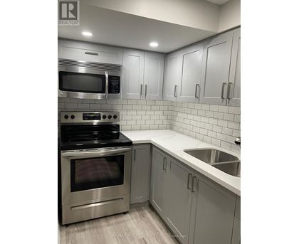 A modern kitchen with a stainless steel oven and microwave.