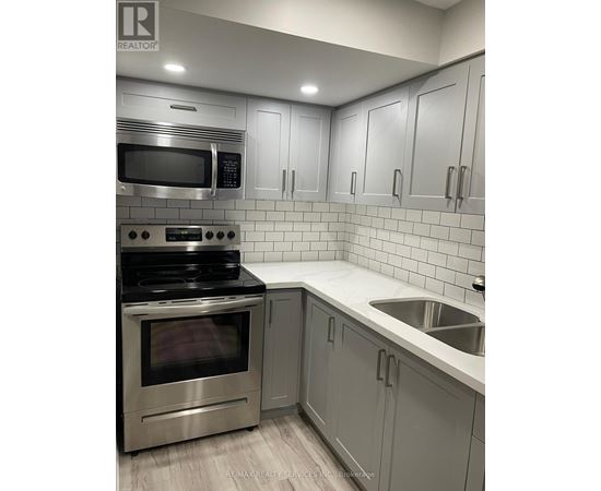 A modern kitchen with a stainless steel oven and microwave.