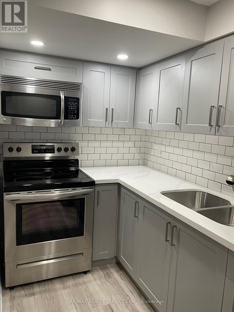 A modern kitchen with a stainless steel oven and microwave.