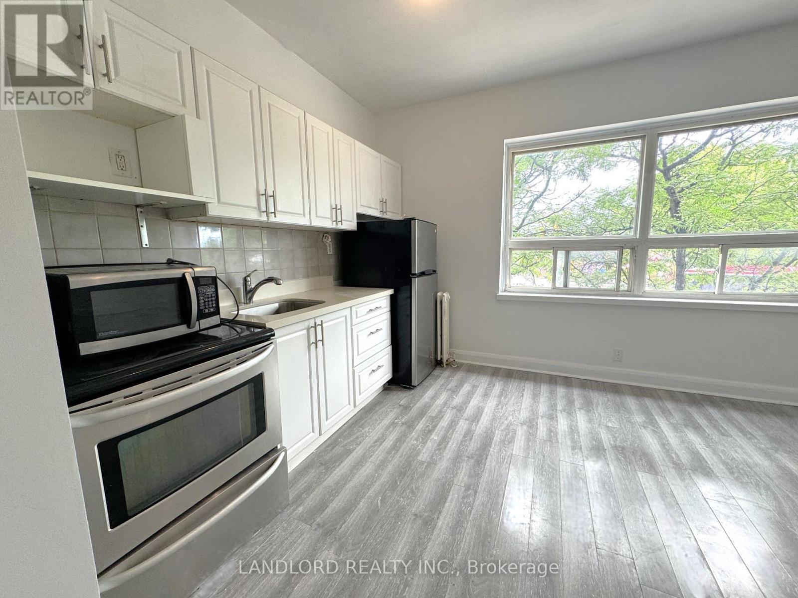 A kitchen with white cabinets and black appliances.