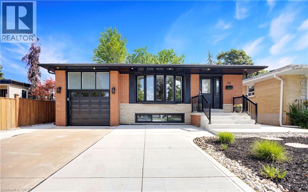 A modern house with a black garage door is for sale.