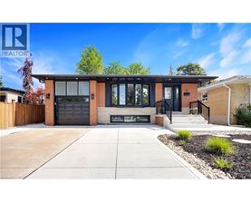 A modern house with a black garage door is for sale.