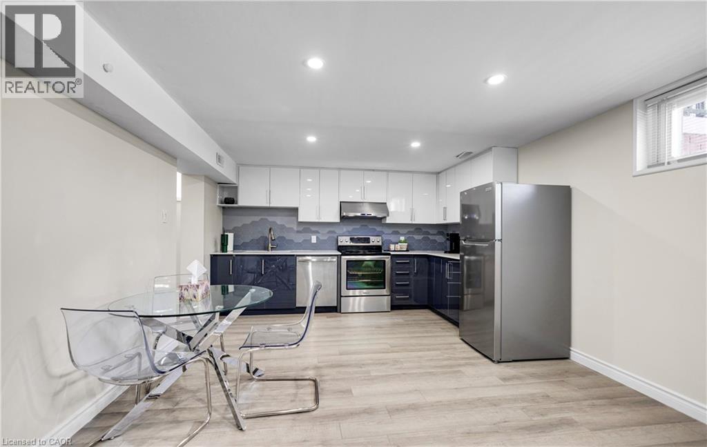 A modern kitchen with a glass table and stainless steel appliances.