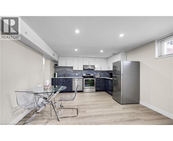 A modern kitchen with a glass table and stainless steel appliances.