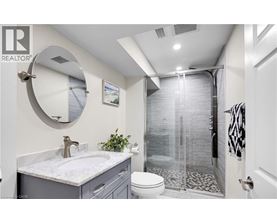 A bathroom with a white sink and a round mirror.
