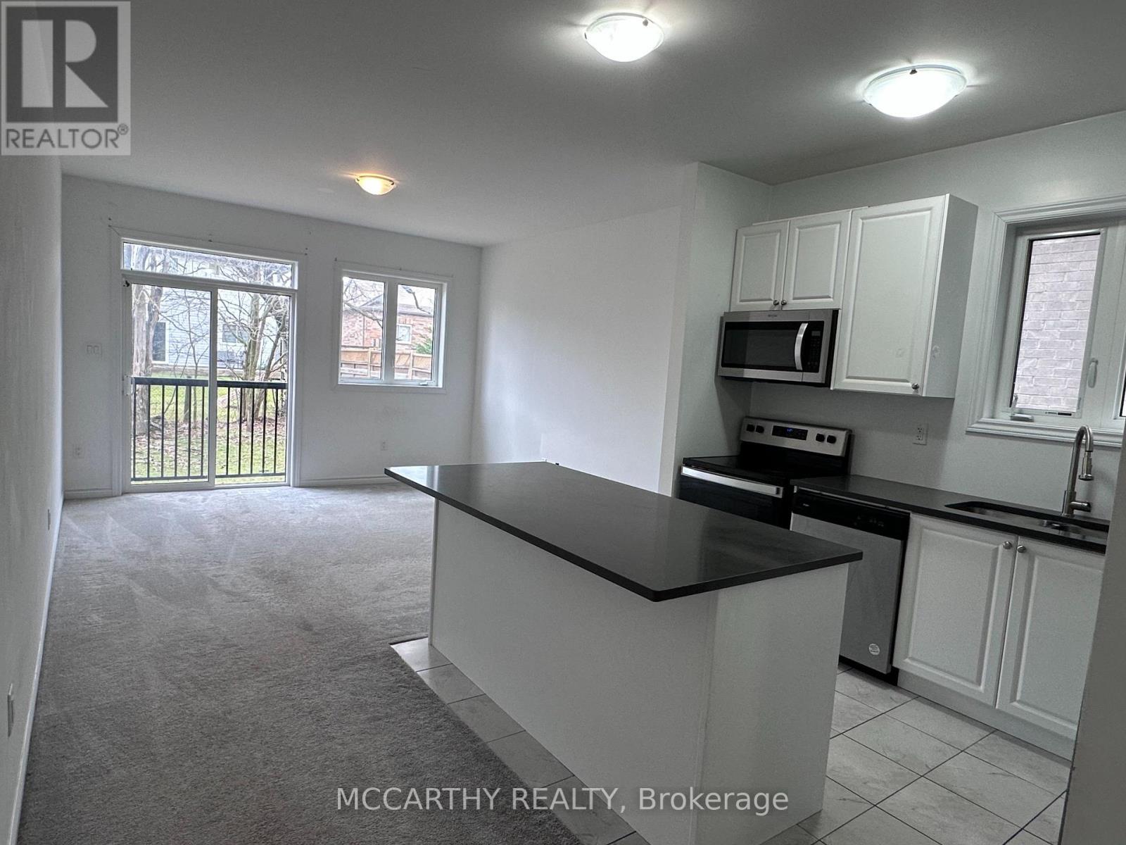 A kitchen with a black countertop and white cabinets.