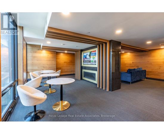 A modern office space with a wood panelled wall and a television screen.