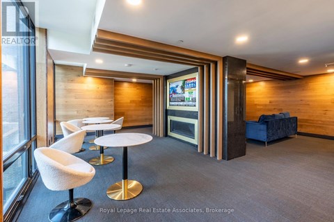 A modern office space with a wood panelled wall and a television screen.