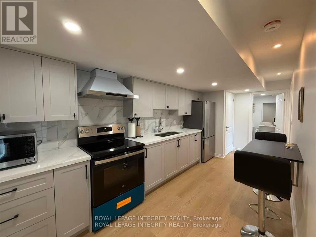 A kitchen with white cabinets and a black counter.