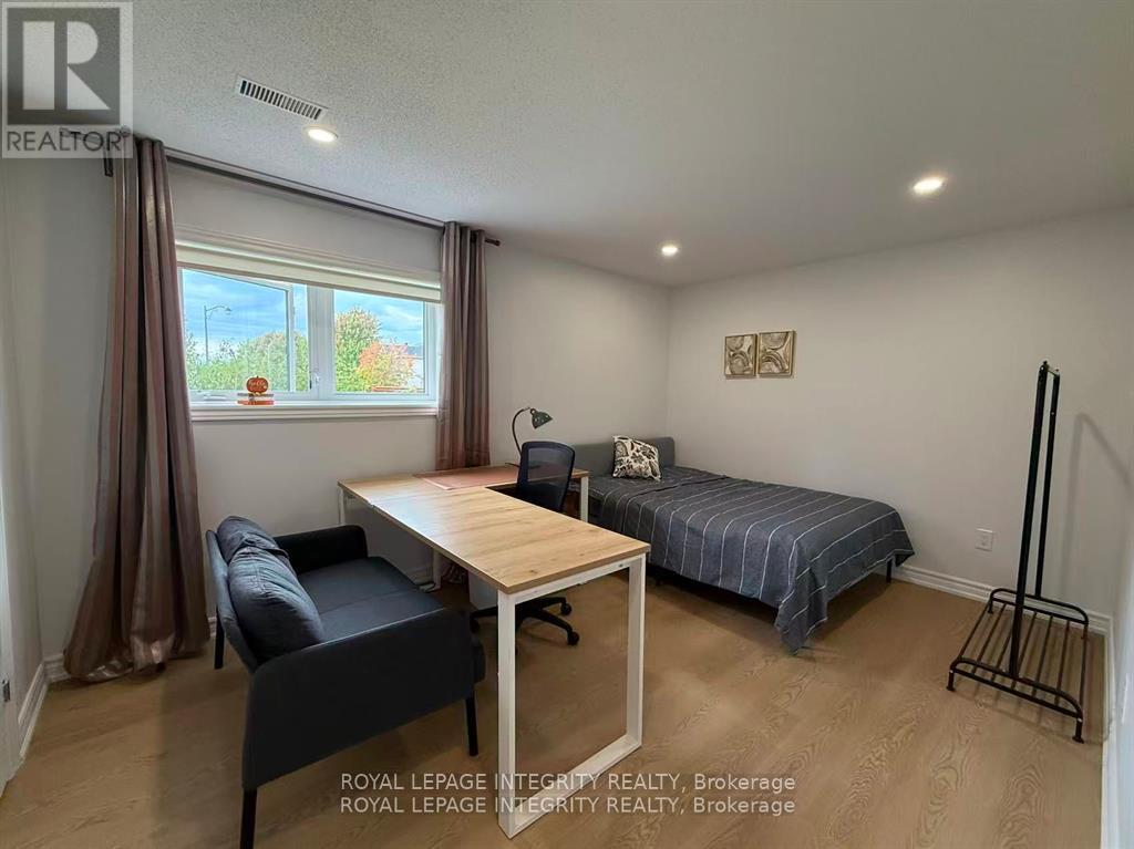 A bedroom with a bed, chair, and desk.