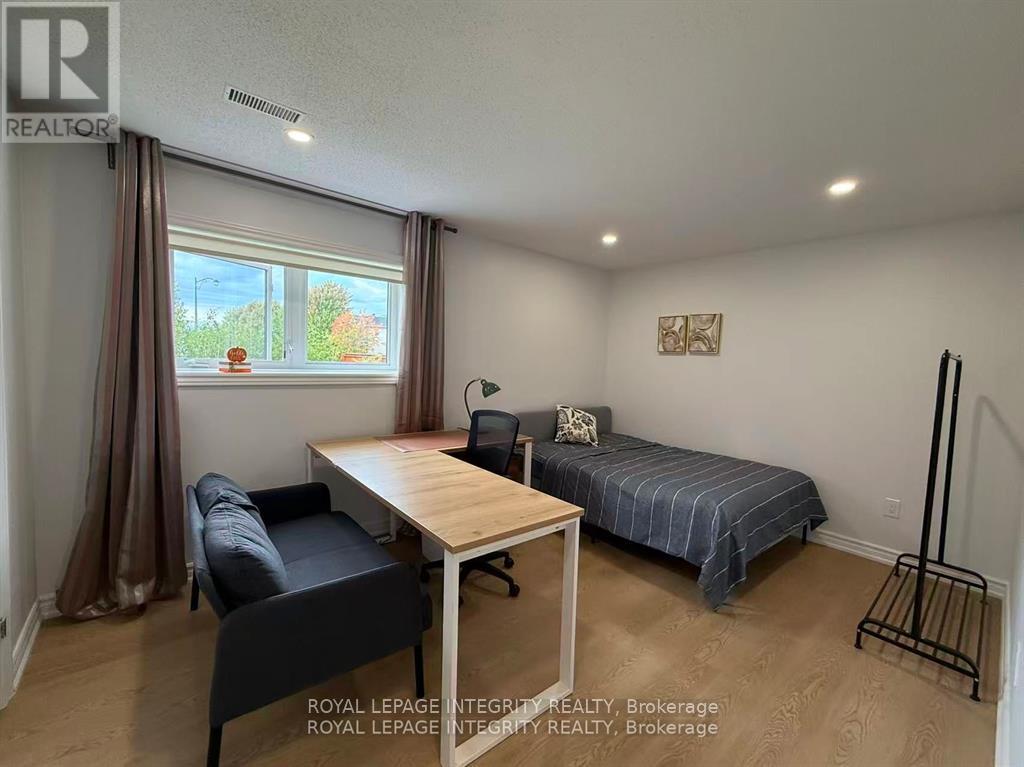 A bedroom with a bed, chair, and table.