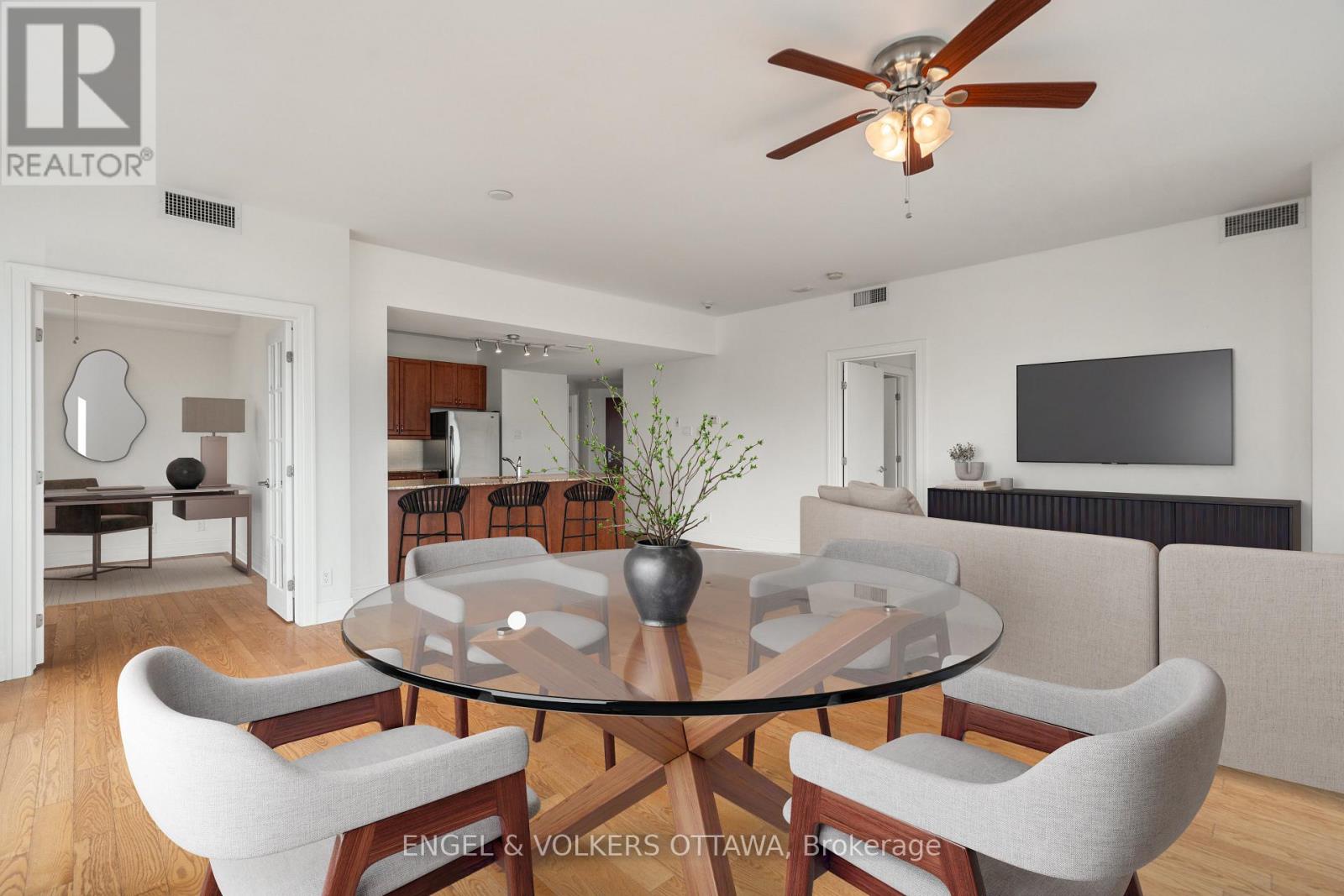 A modern dining room with a glass table and chairs.