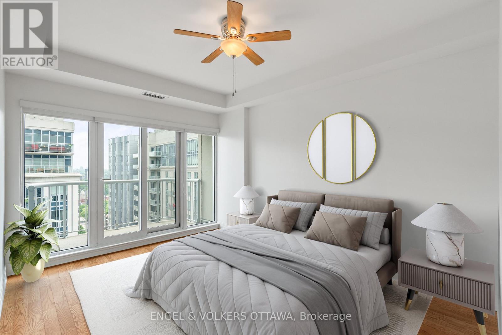 A bedroom with a bed, a ceiling fan, and a window overlooking a cityscape.
