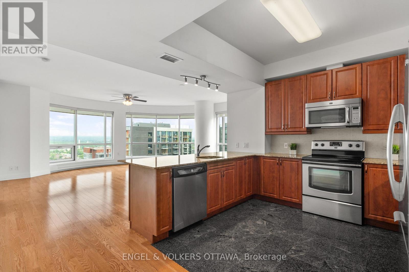 A kitchen with wooden cabinets and a black dishwasher.