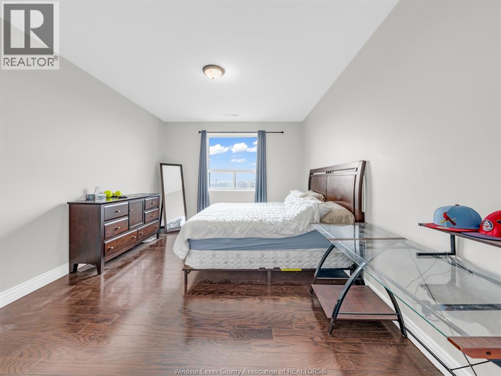 A bedroom with a bed, dresser, and window.