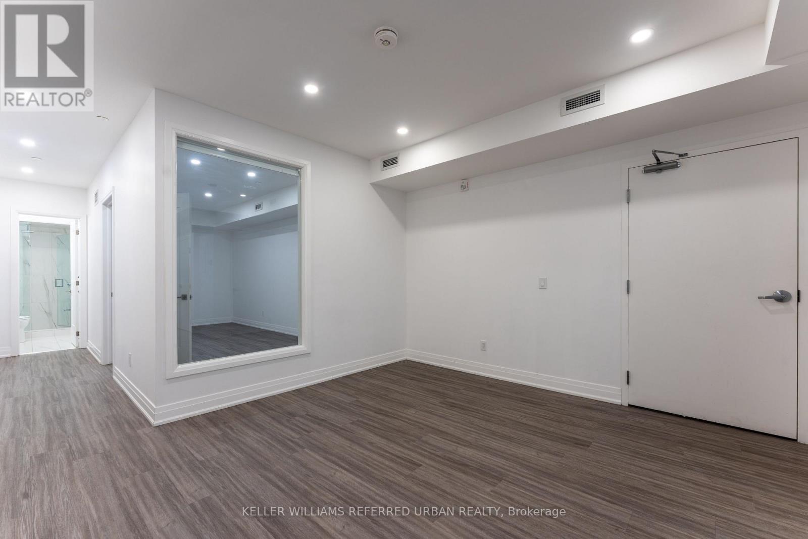 A spacious room with a large mirror on the wall.