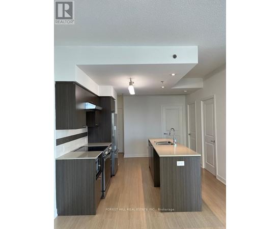 A modern kitchen with dark wood cabinets and a white island.