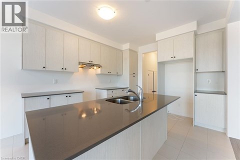 A kitchen with white cabinets and a brown countertop.