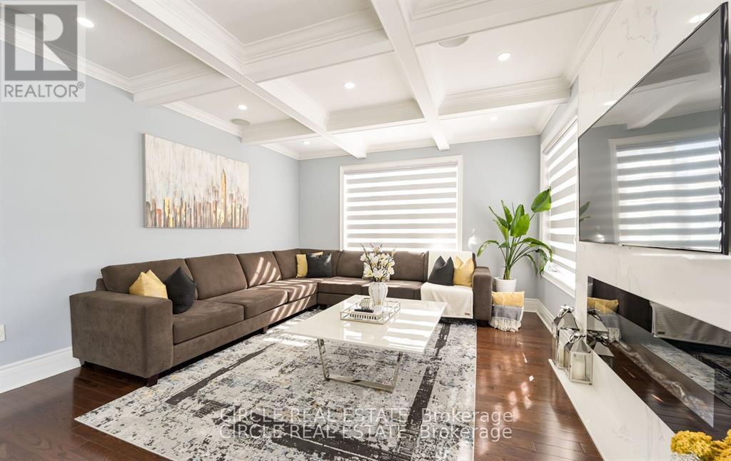 A living room with a brown couch and a rug.