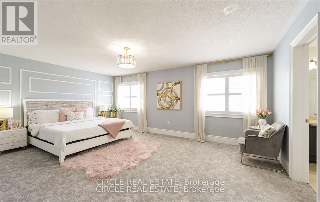 A well-lit bedroom with a large bed and a chair.