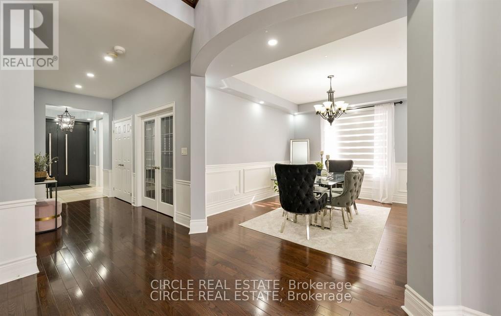 A well-lit, spacious dining area with a chandelier and a table set for four.