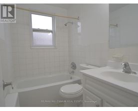 A white bathroom with a toilet, sink, and tub.