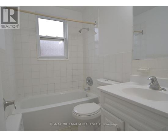 A white bathroom with a toilet, sink, and tub.