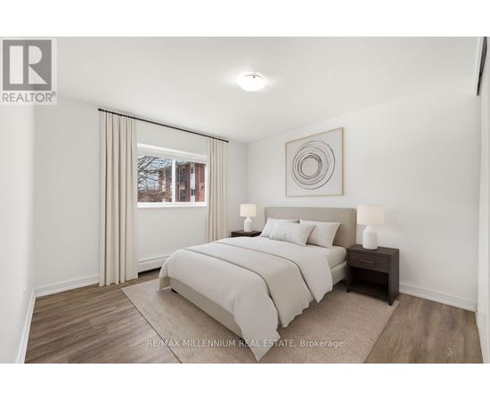 A bedroom with a large bed and a window with curtains.