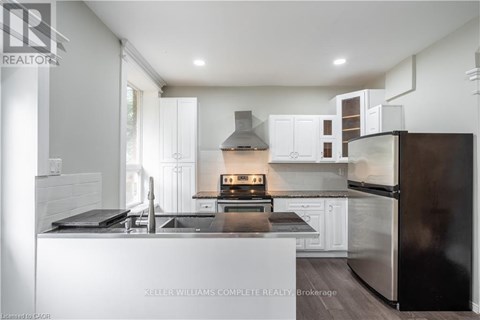 A modern kitchen with a stove top oven and a refrigerator.